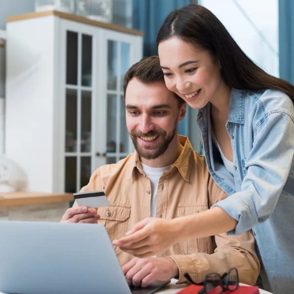 A young couple shopping online together on a laptop, exploring options for a same day loan.